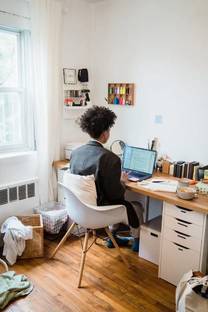 a person working on laptop on a desk at fixed starting time to improve working from home